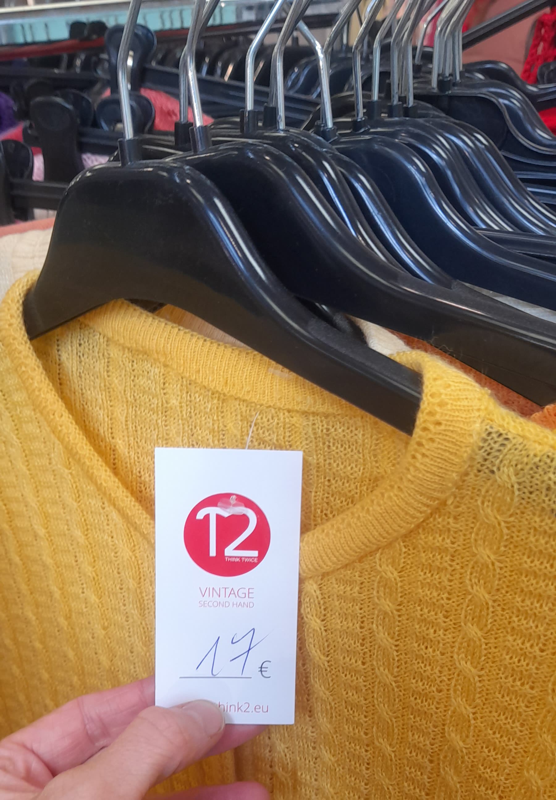 Jersey amarillo en una percha con una etiqueta de 17 euros